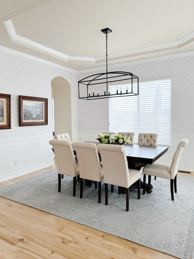 Elegant dining room with a rectangular chandelier and upholstered chairs