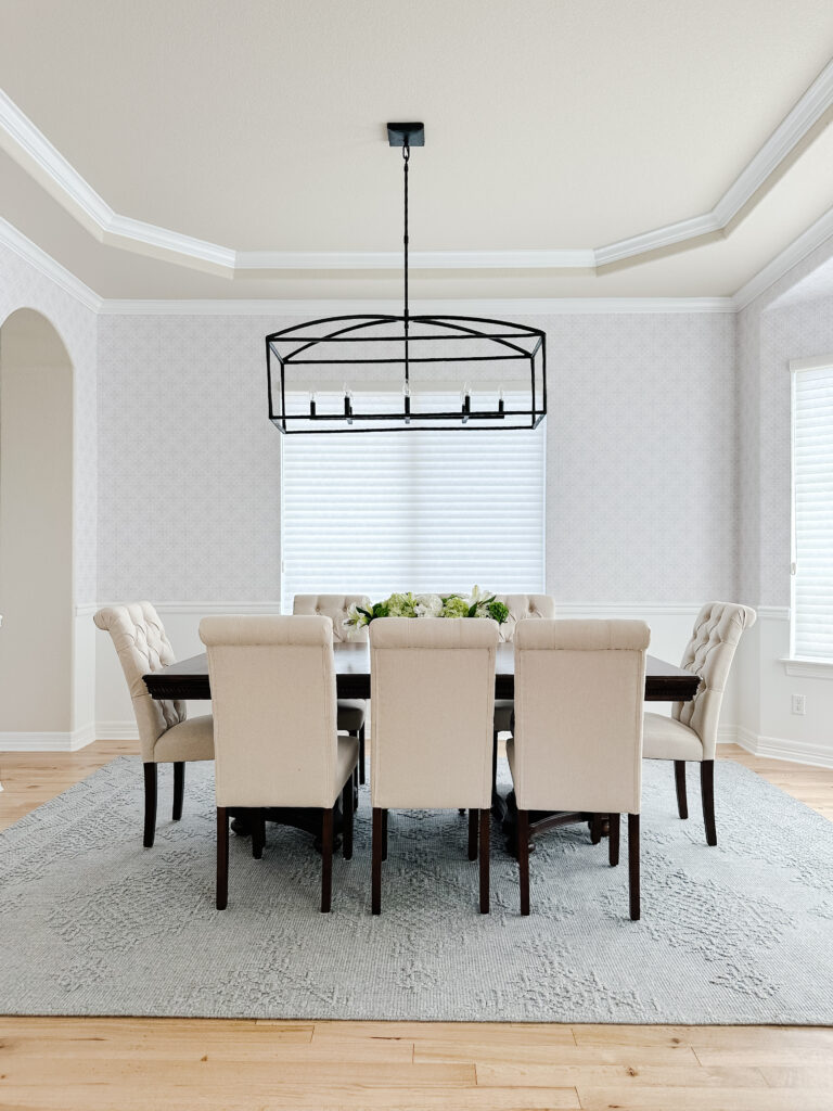 Elegant dining room with a rectangular chandelier and upholstered chairs