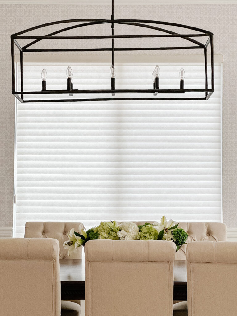 Elegant dining room with a rectangular chandelier and upholstered chairs