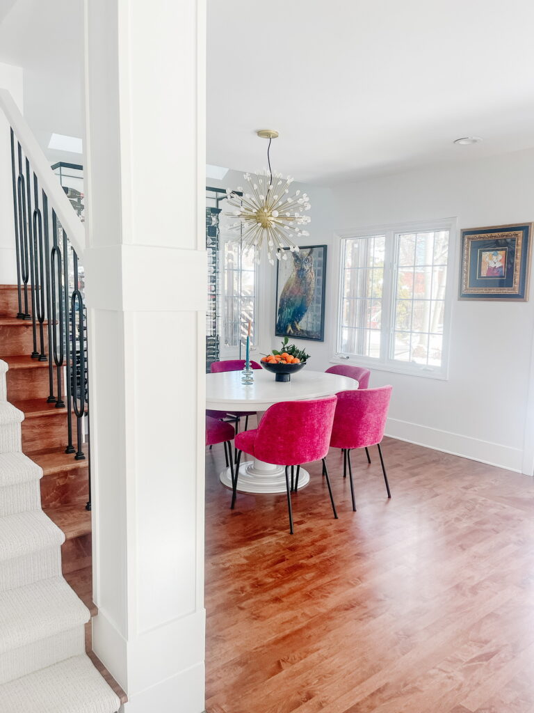 View of dining room, berry colored chairs, sputnik light.