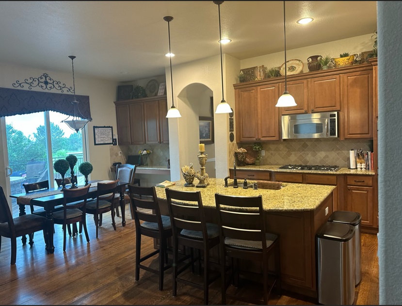 Kitchen with granite island, pendant lights, and dining area